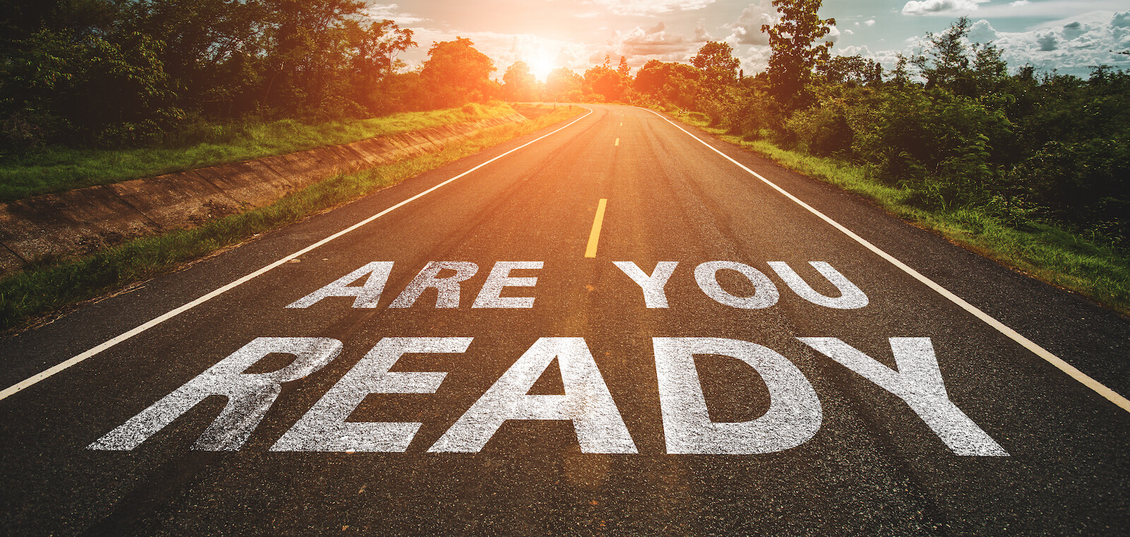 Are you ready written on highway road in the middle of empty asphalt road at beautiful blue sky.